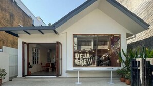 A modern building with a large window displaying the text "DEJA BREW". - DEJA HOME (Chiang Mai)