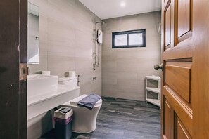 A bathroom with a toilet, sink, and shower area. - DEJA HOME (Chiang Mai)