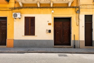 Facciata di un edificio con due porte, una finestra e un condizionatore d'aria.