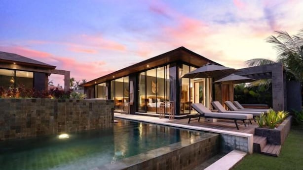 A modern poolside area with a clear pool, lounge chairs, and a covered seating area. - Villa Palm Angels by BaliSuperHost (Bali)