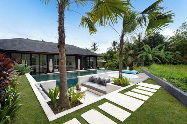 A modern house with a swimming pool, outdoor seating, and tropical plants. - Villa Palm Angels by BaliSuperHost (Bali)