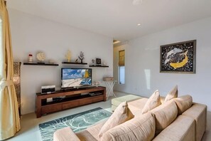 A living room with a sofa, TV, and artwork on the wall. - Perfect Pool Villa with Jacuzzi Three Bedrooms Villa No.5 (Phuket)