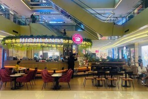 Zona de restauració amb seients i una cafeteria anomenada 'HIGHLANDS'.