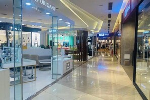 Interior de un centro comercial moderno con escaparates de vidrio, una zona de descanso y un suelo limpio y pulido.