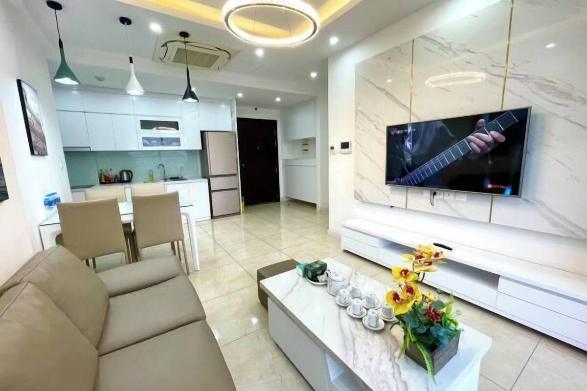 Ein modernes Wohnzimmer mit einer Couch, einem Couchtisch und einem an der Wand montierten Fernseher.
