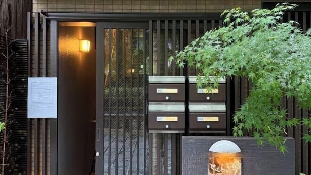 A traditional Japanese-style entrance with a sliding gate, a small outdoor seating area, and a signboard. - Yasen (Kyoto)