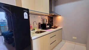 Una cocina compacta con refrigerador, pileta y estufa.