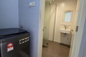 Un baño con lavamanos, espejo y cabina de ducha.