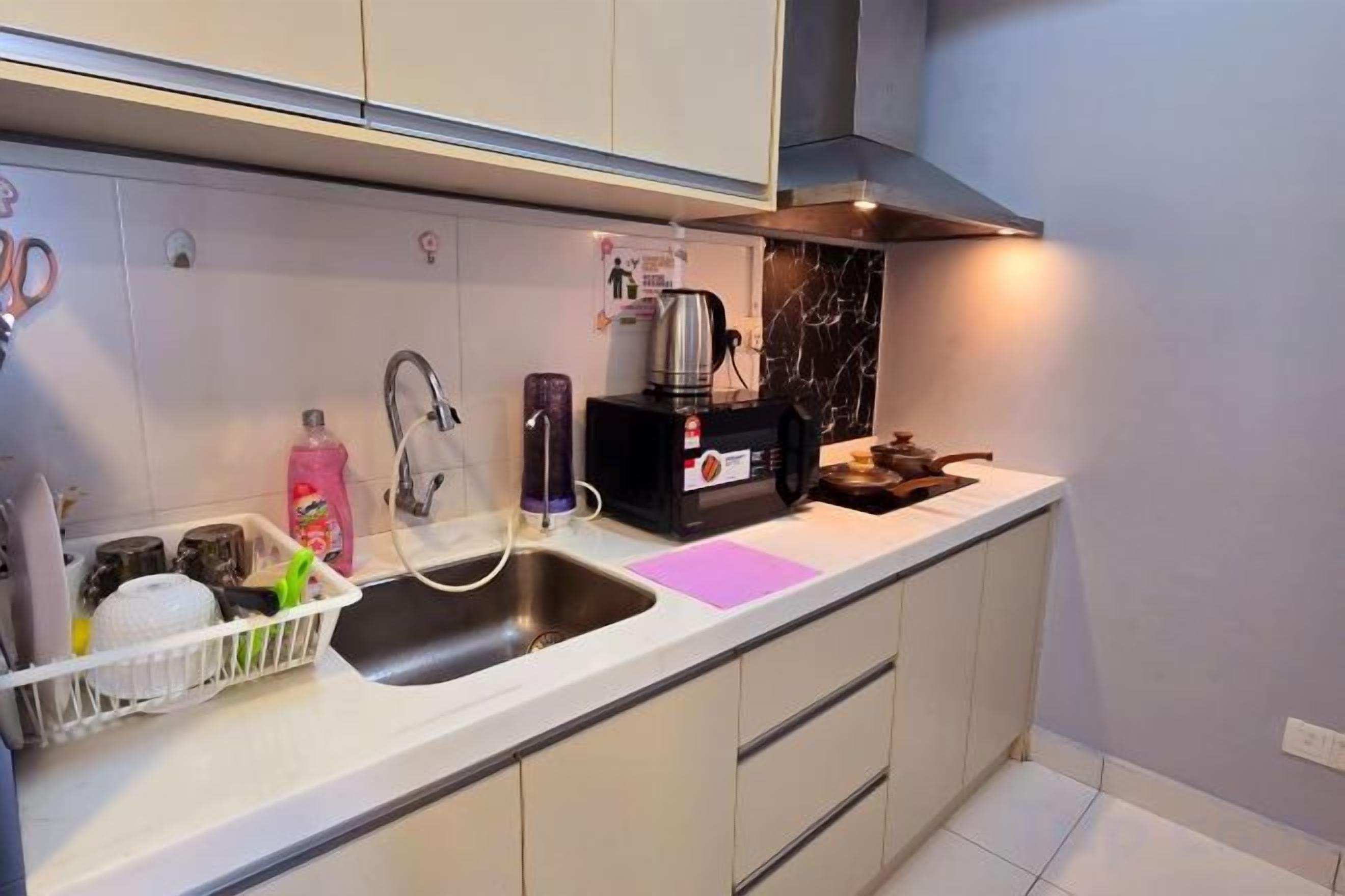 A modern kitchen with a sink, coffee maker, and a dish rack.