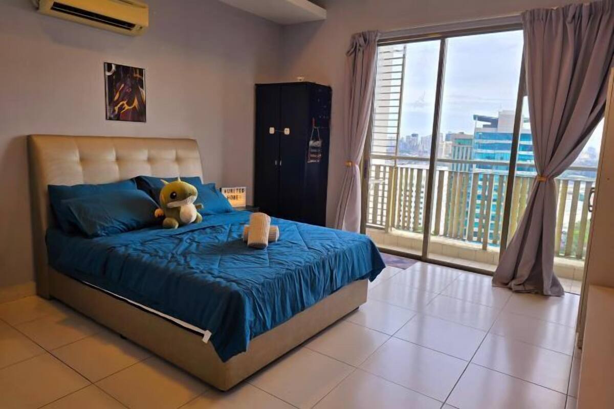 Ein Schlafzimmer mit Bett, Kleiderschrank, einem Balkon mit Blick auf Gebäude und einer Klimaanlage.