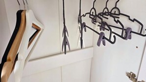Una habitación blanca con una barra de cortina blanca y una silla de madera.