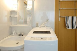 A bathroom with a sink, a mirror, a towel rack, and a washing machine. - Prosupa6 2F (Nagoya)
