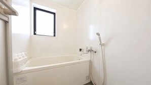 A white bathroom with a bathtub, a window, and a shower. - Prosupa6 2F (Nagoya)