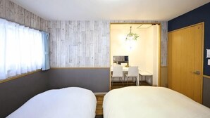 A room with two beds, a desk, and a chair, with a wooden door and a curtain on the window. - Prosupa6 2F (Nagoya)