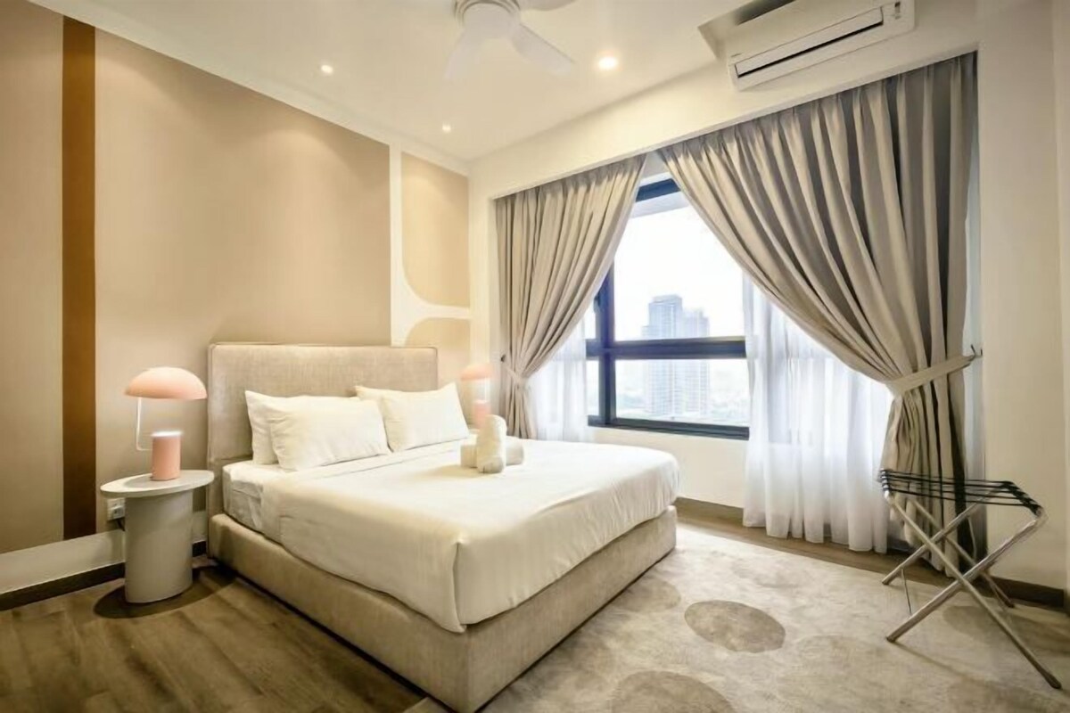 Une chambre à coucher moderne avec un grand lit, une table de chevet avec une lampe et une fenêtre avec des rideaux.