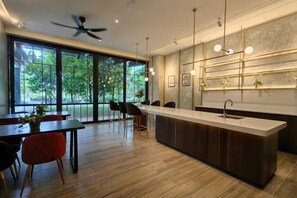 A modern kitchen with a central island, large windows, and a dining area with chairs. - TRX Agile Bukit Bintang Suites (Kuala Lumpur)