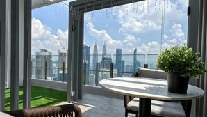 Een balkon met uitzicht op een stadshemelbeeld, een ronde tafel en een potplant.