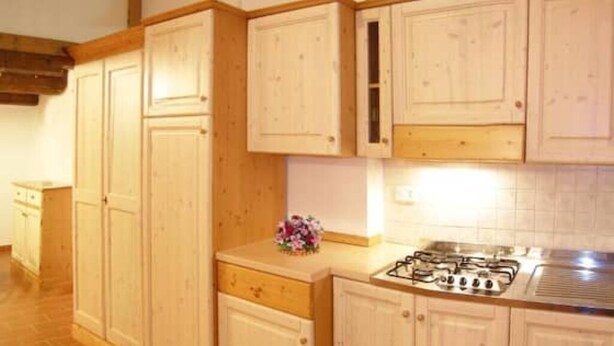 A kitchen with wooden cabinets, a gas stove, and a tiled backsplash. - Apartment 16 for 4 Guests (Castel del Piano)