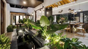A modern interior with a dining area, a kitchen, and a living space. - Jami 4BR PoolVilla, a Serenity Steps from theBeach (Bali)