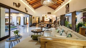 A spacious living area with a high ceiling, wooden beams, and a central dining area. - Jami 4BR PoolVilla, a Serenity Steps from theBeach (Bali)