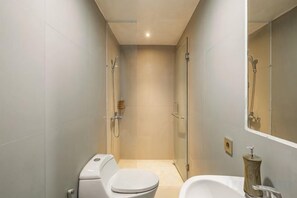Et moderne badeværelse med toilet, bruser og badekar.