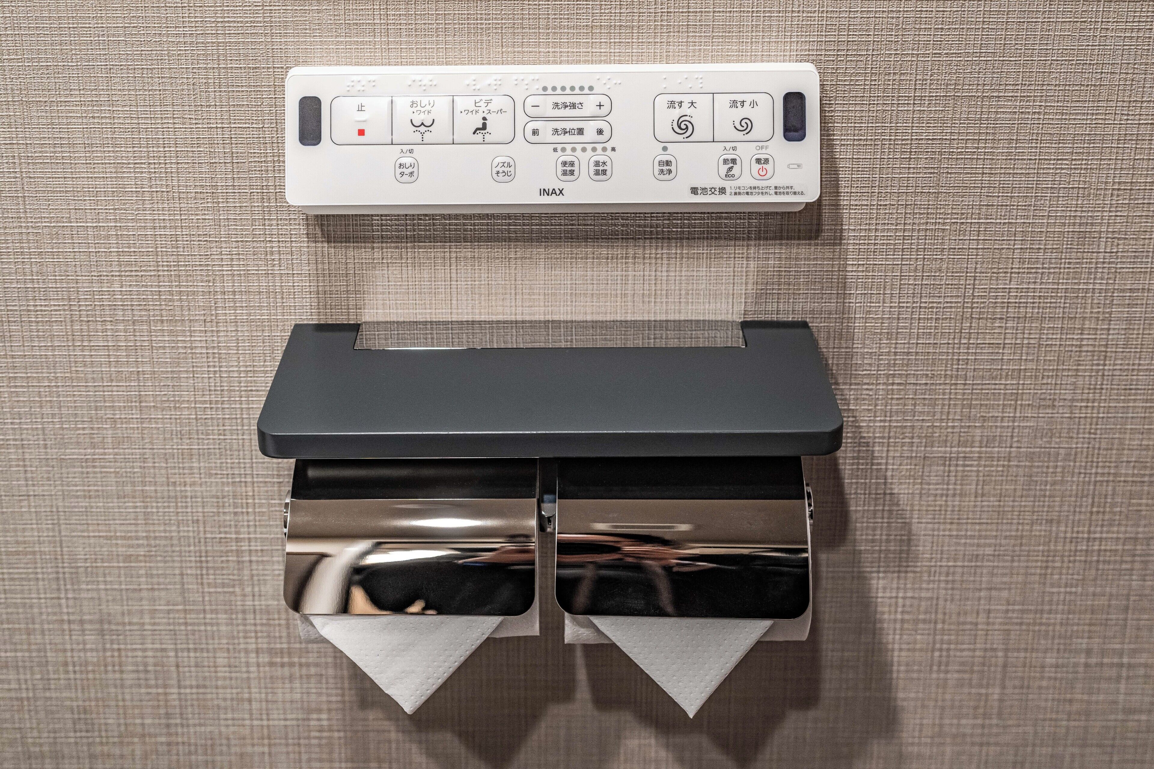 Panel de control montado en la pared con varios botones e indicadores, probablemente para los servicios de una habitación de hotel.