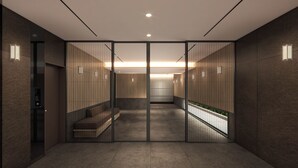 A modern interior with a central staircase, a seating area, and a glass partition. - Apartment Hotel 11 Shinimamiya 3 (Osaka)
