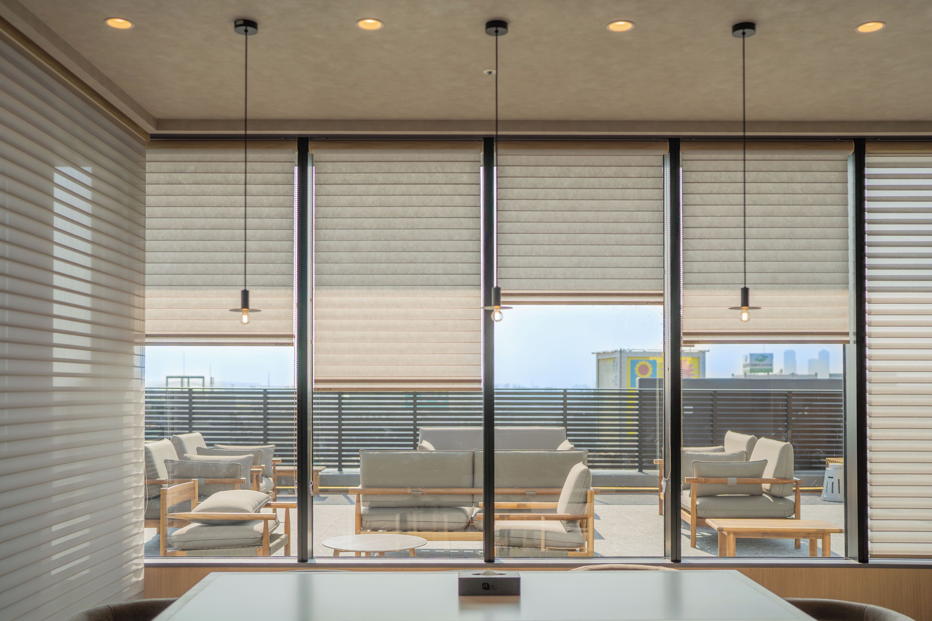 A modern interior with large windows, a conference table, and seating.