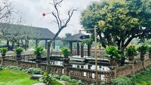 Ein traditioneller Garten mit Holzzaun, Kübelpflanzen und einem Gazebo.