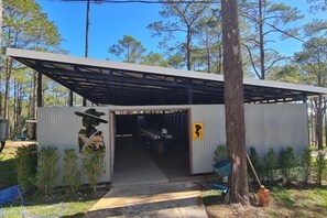 Un edificio metálico con una entrada cubierta y un letrero que indica un baño.