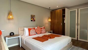 Un dormitorio con cama, mesitas de noche, armario y closet con puerta corrediza.