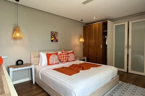 A bedroom with a bed, bedside tables, a wardrobe, and a sliding door closet. - Baan Talay BeachFront Pool Villa A (Koh Samui)