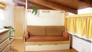 A cozy room with a wooden bench, a potted plant, and a window with curtains. - Apartment 21 with 1 Bedroom - Perfect for 4 Travelers (Castel del Piano)