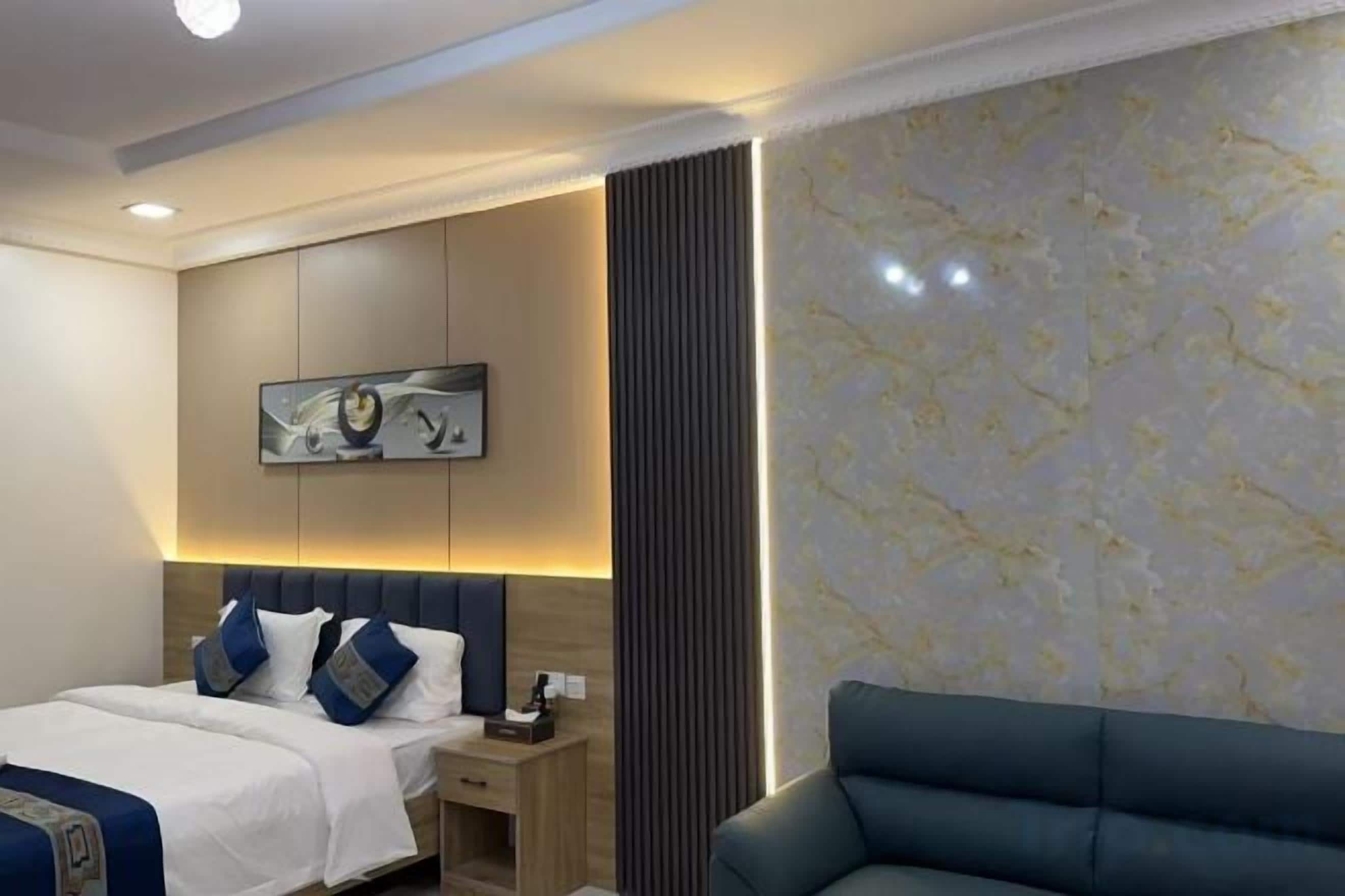 Una habitación de hotel con cama, mesita de noche y zona de estar.