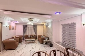 A living room with a sofa set, a coffee table, and a chandelier. - Star Wish Business Hotel (Ikeja)