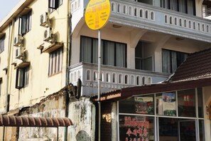 A building with a balcony and a signboard. - V V Guesthouse (Vang Vieng)