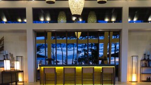 A pool area with a fire pit in the foreground and a bar area with seating in the background. - ALTA VISTA BALI MOUNTAIN VILLAS (Wanagiri)