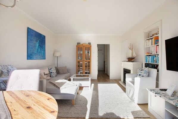 A modern living room with a sofa, coffee table, and a bookshelf.