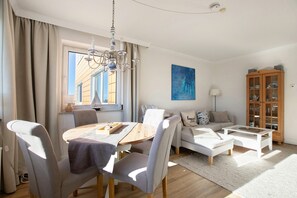 A modern living room with a dining table, sofa, and coffee table.