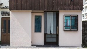 Een gebouw met een houten gevel, een deur en een raam.