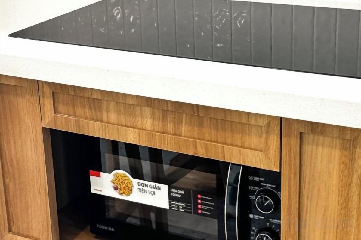 Une cuisine équipée d’un four à micro-ondes encastré et d’un panneau de commande.