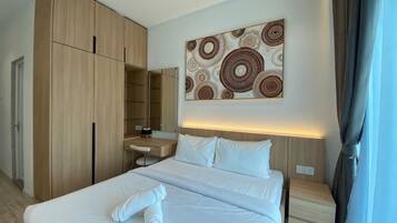 A hotel room with a large bed, a bedside table, a wardrobe, a mirror, and a wall art piece.