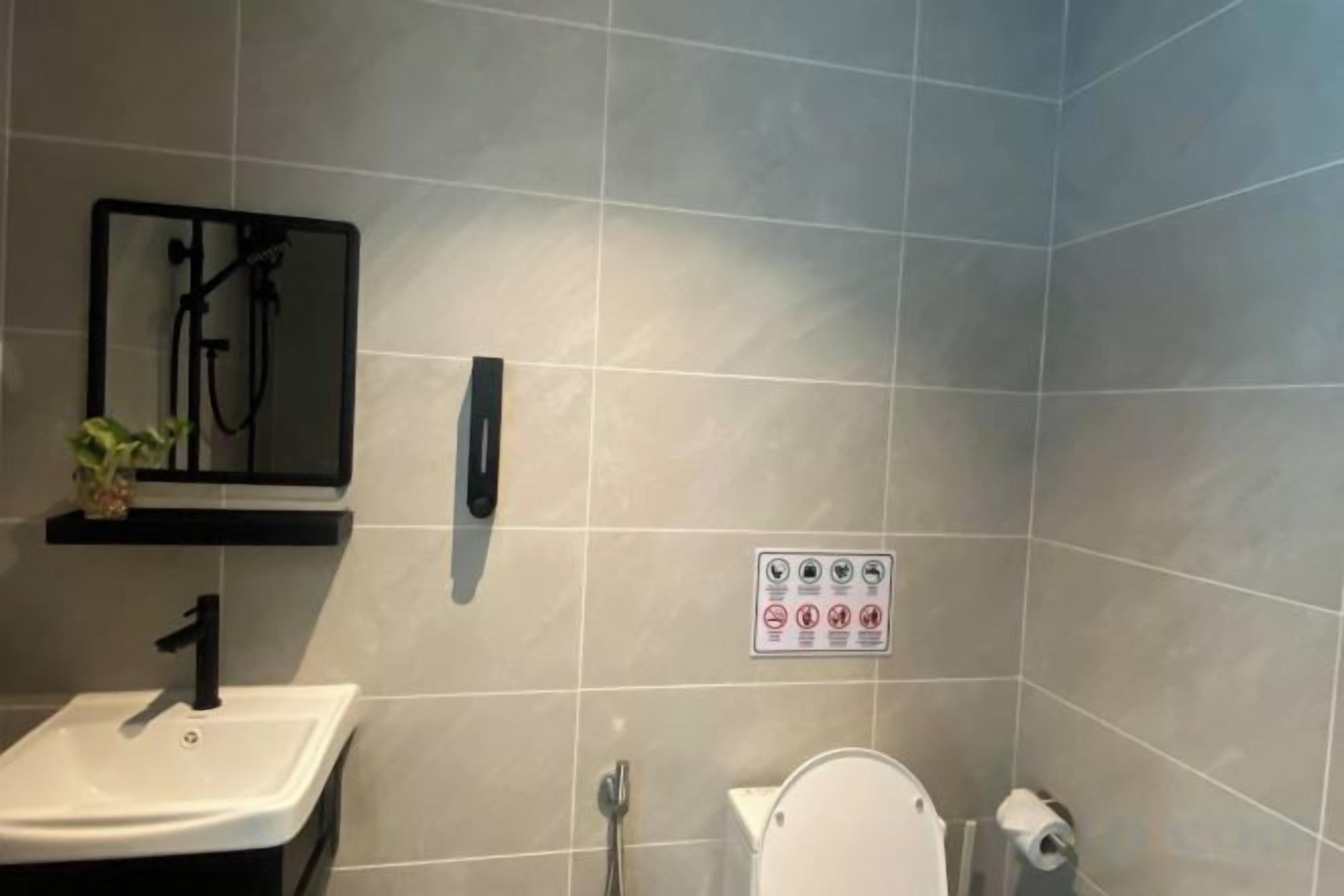 A bathroom with a sink, toilet, and a shower area.