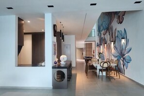 Un comedor moderno con un mural, una escalera y un mostrador de recepción.