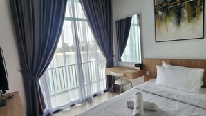 A hotel room with a bed, a desk, a chair, and a large window with curtains. - Oceanfront- Laman Green Villa, Port Dickson (Port Dickson)