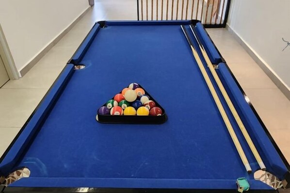 A pool table with a triangular rack of billiard balls and two cue sticks. - Oceanfront- Laman Green Villa, Port Dickson (Port Dickson)