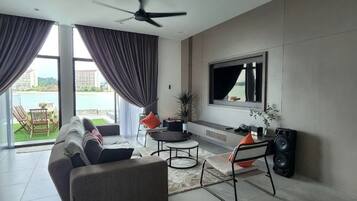 A modern living room with a sofa, coffee table, TV, and a ceiling fan.