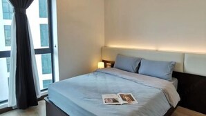 A hotel room with a bed, a nightstand, a lamp, and a window with curtains. - Private Lift 5star Home Seaview Permas / Senibong Cove / Mid Valley Johor (Masai)