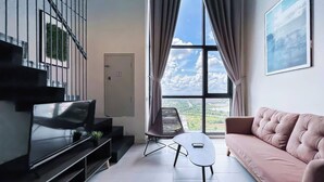 Ein modernes Wohnzimmer mit Fernseher, Sofa und Tisch.