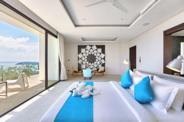 A modern hotel room with a large bed, a view of the sea, and a dining area with a unique wall design. - Turquoise Villa 2 GYM and KIDS ROOM (Koh Samui)